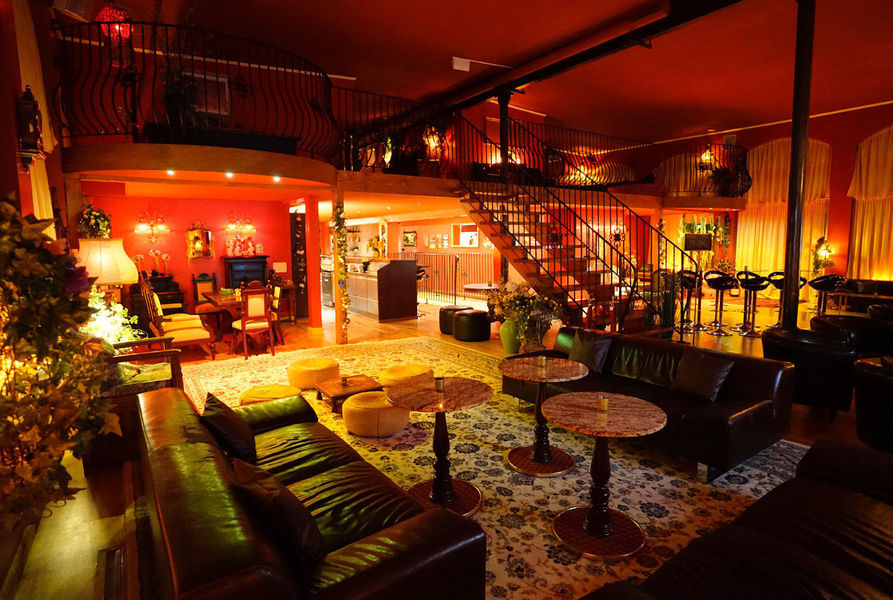 Der grosse Salon mit Ledersofas, Teppichen und Marmortischen unter der Galerie